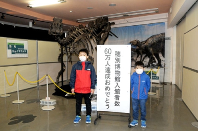写真：カムイサウルスの骨格標本前で記念写真に納まる高橋厚治君（左）と亮治ちゃん