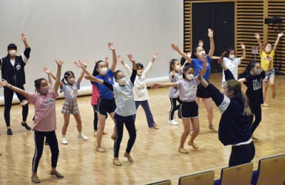 写真：小学生にチアダンスの振り付けを教える「ＪＥＴＳ」の卒業生（右手前）＝４月、福井市