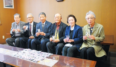 写真：草塩会長（左から３番目）に手作りマスコットを寄贈した老人クラブ連合会の関係者