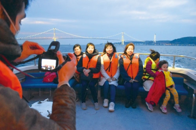 写真：白鳥大橋を背景に記念撮影を楽しむ参加者