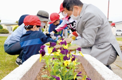 写真：丁寧に花を植え替える児童たち