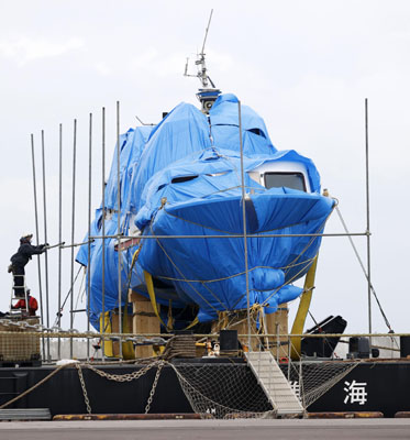 写真：網走港に接岸した観光船「ＫＡＺＵ　Ⅰ」の周囲で行われた作業＝２７日午後