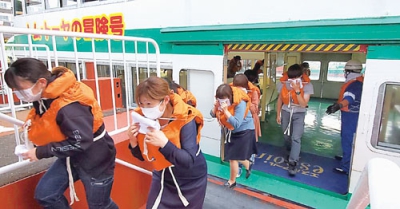 写真：遊覧船から桟橋へ避難する訓練参加者