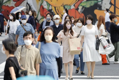 写真：東京・有楽町をマスク姿で歩く人たち＝１３日