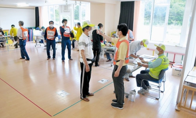 写真：避難所開設の訓練に臨む参加者たち＝あいくる