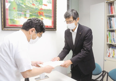 写真：企業リストを手渡して学生の地元就職を呼びかける松永副会頭（右）