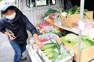 写真：軽トラの荷台に満載した野菜の値段を付ける館山さん＝７日午前