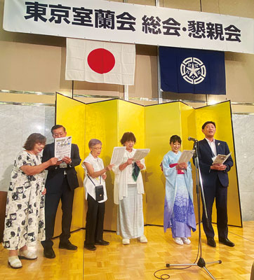 写真：東京室蘭会の親睦会の最後に「室蘭市の歌」を歌う青山市長（右）ら参加者