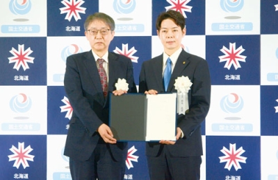 写真：柿崎局長（左）から引き渡し目録を受けた鈴木知事