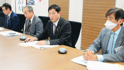 写真：臨時株主総会後の記者会見でまちづくりへの思いを語る青山市長（左から３人目）ら＝昨年１２月