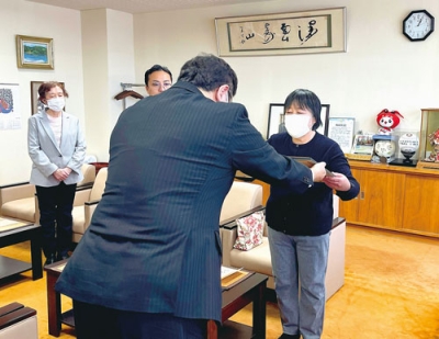 写真：小笠原市長から位記を受け取る伴子さん（右）