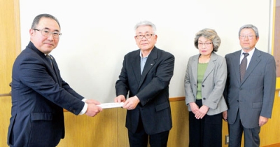 写真：渋川教育長（左）に善意を手渡す越前谷会長