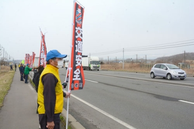 写真：「交通安全」と書かれたのぼり旗を掲げる参加者