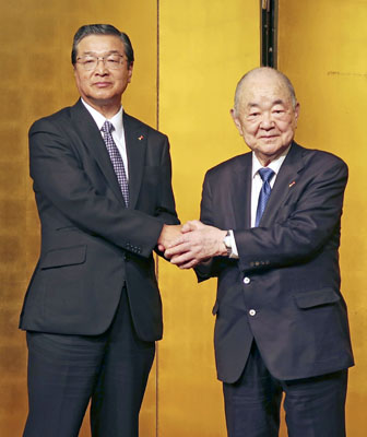 写真：握手するアークスの横山清社長（右）と次期社長に就任予定の猫宮一久氏＝１５日午後、札幌市