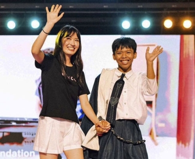 写真：ファッションショーの舞台に立つ西側愛弓さん（左）とモデルの子ども＝２月、マニラ（西側さん提供、共同）