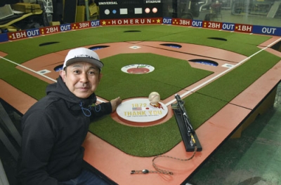 写真：「ユニバーサル野球」で使われる巨大な野球盤と開発者の中村哲郎さん＝８日、埼玉県所沢市