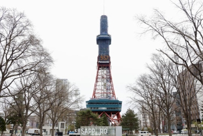 写真：補修工事のため、一部が青いネットで覆われた「さっぽろテレビ塔」＝２２日午前、札幌市