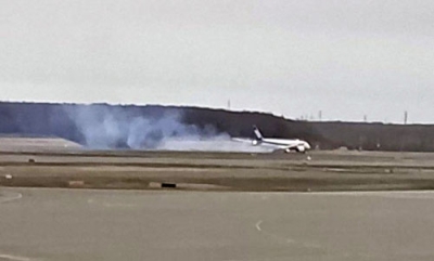 写真：煙を出し着陸する全日空機＝２４日午後、新千歳空港（マドリガル提供）