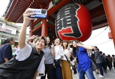 写真：ゴールデンウイークが始まり、東京・浅草の雷門前で記念撮影をする北海道や新潟から訪れた観光客のグループ＝２７日午後
