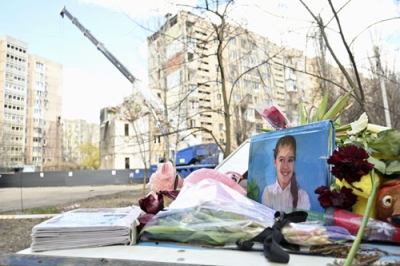 写真：ロシアの無人機攻撃を受けたアパートの脇に、亡くなった子どもの写真や花が手向けられていた＝３月２９日、ウクライナ・オデッサ（共同）