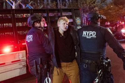 写真：４月３０日、ニューヨーク市立大でデモ参加者を拘束する警察官＝ニューヨーク（ゲッティ＝共同）