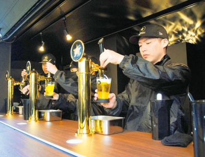 写真：厳格な審査をクリアした生ビールをサーバーから注ぐスタッフ