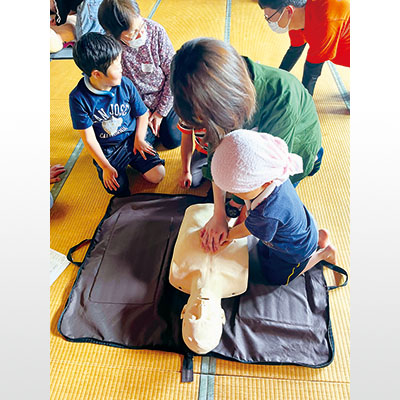 写真：心肺蘇生法を学ぶ子ども（提供写真）
