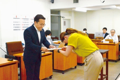 写真：宮武委員長から答申書を受け取る辻議長（左）