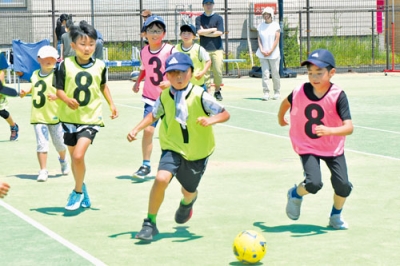 写真：広い敷地内でサッカーを楽しむ子どもたち