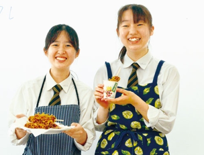 写真：完成した「かなぼう餃子」を手にする（右から）武藤さんと岡田さん