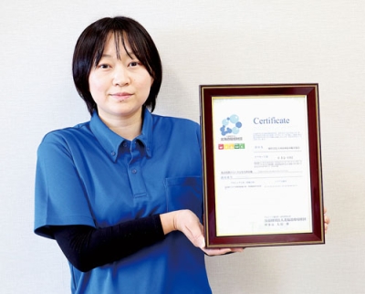 写真：カーボンオフ・セットの証明書を手にする横山さん