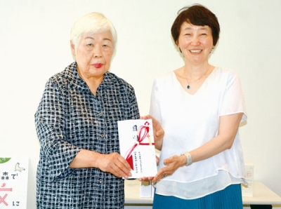写真：目録を手渡す小松社長（右）と吉田委員長