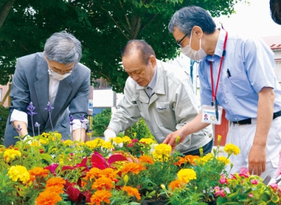 写真：花壇に花植えをする吉野会長ら