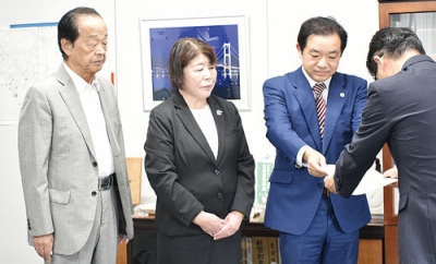 写真：高橋教育局長に協力要請書を手渡す増川弁護士（右から２人目）ら