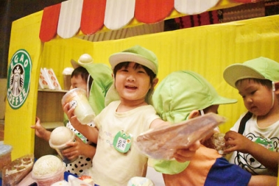 写真：「食べ物どうぞ」カフェ店員になりきり商品を手渡す園児