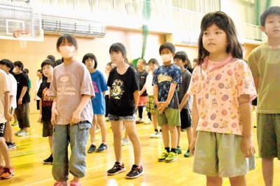 写真：アイスリングなど暑さ対策をして校歌を歌う児童たち