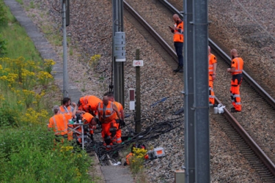写真：２６日、高速列車網への破壊行為があった現場で作業するフランス国鉄の職員ら＝フランス北部（ロイター＝共同）