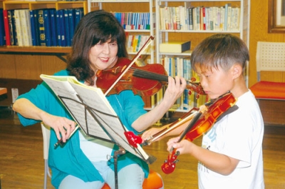 写真：発表会に向けて指導を行う吉井さん（左）