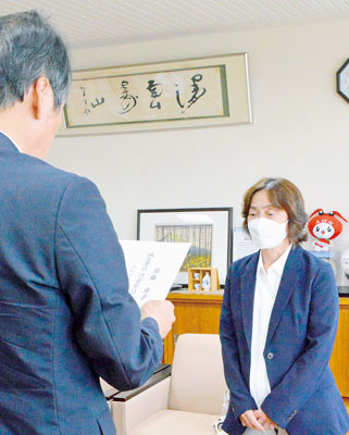 写真：伊藤副市長から委任状を受け取る須藤さん（右）