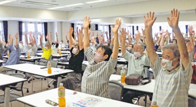 写真：笑いヨガで楽しく体を動かす会員たち