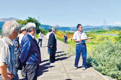 写真：長流川流域の視察を行う懇談会出席者ら