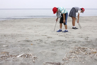 写真：鹿児島県・下甑島の青瀬海水浴場に漂着したごみを拾う子どもたち＝８月