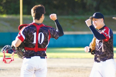 写真：完封勝利を収め、日本製鉄室蘭コークス・吉田（左）とグータッチする永井＝中島公園野球場