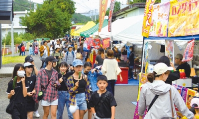 写真：市道を歩行者天国にして露店が並び多くの人で賑わう本輪西八幡神社例大祭