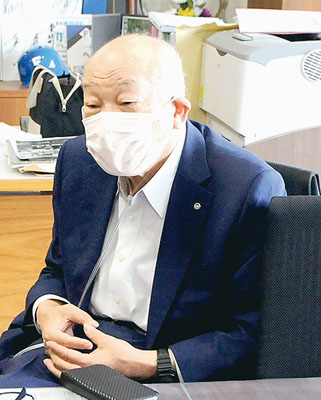 写真：任期途中の辞任について語る村井町長