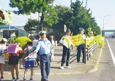 写真：児童たちに交通安全を呼びかける参加者たち