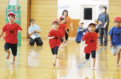 写真：運動会のかけっこで元気いっぱいに走る園児たち