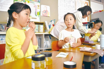 写真：甘い蜂蜜の食べ比べを楽しむ児童たち