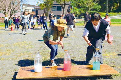 写真：水入れリレーを楽しむ参加者たち