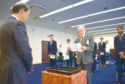 写真：松田学長に宣誓する山之内さん